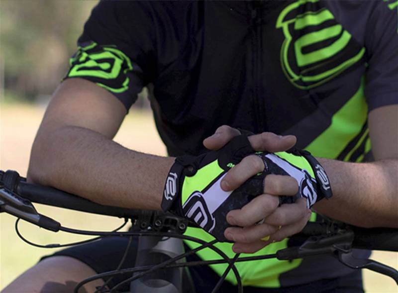 Imagem focada em mão de ciclista utilizando luvas para a prática de ciclismo