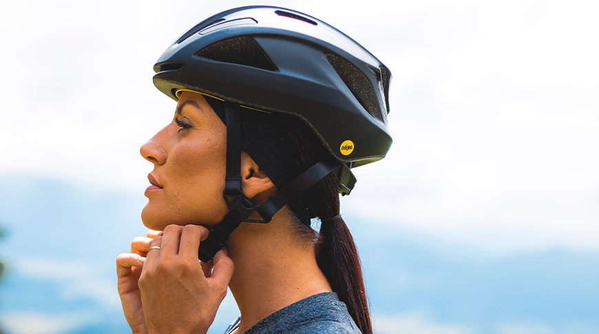 Imagem com uma mulher vestindo um capacete para ciclismo em foco